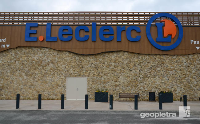 Facade of an E.Leclerc supermarket with signage on slats and dry-stacked manufactured stone cladding by Geopietra.